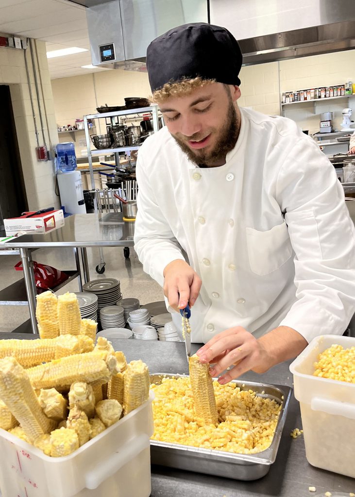 A student cuts corn