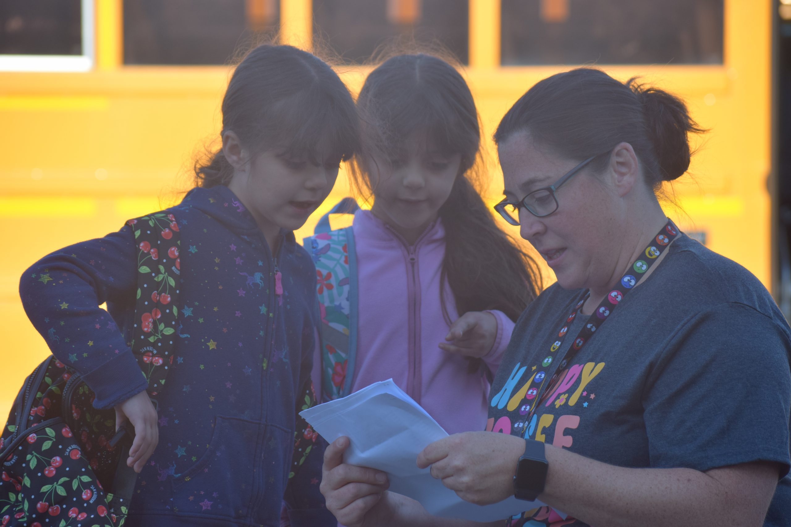 a staff member helps two students