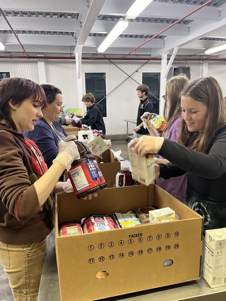 Several students pack a box