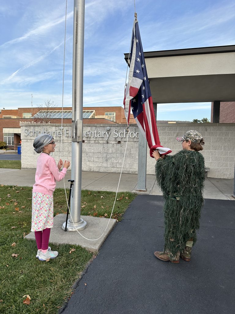 two students raise a flag