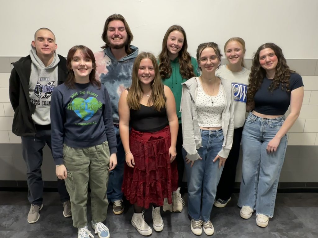 Eight students stand