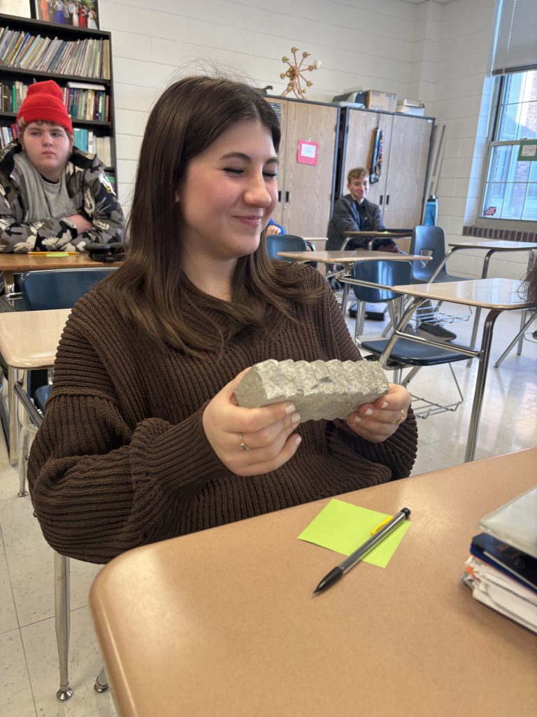 A student handles an object