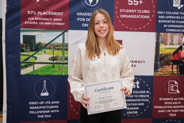 A student holds a certificate