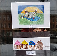 two piece of student art hang in a window